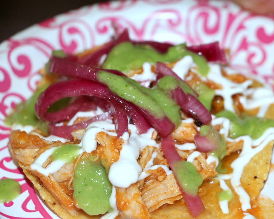 Chicken tinga tostadas with fresh green salsa and pickled red onions.